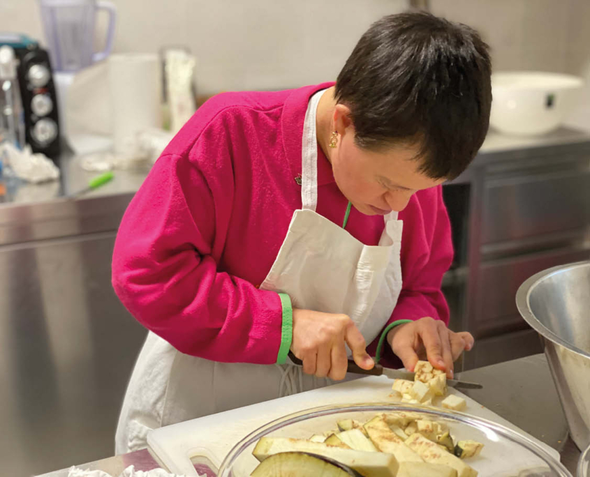 Una donna che taglia le verdure. Foto scattata durante l'attività di Potenziamento Cognitivo adulti e attività di prevenzione della demenza senile.