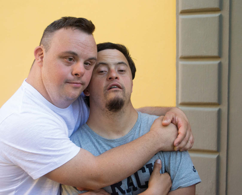 Due giovani adulti dell'associazione che si abbracciano.