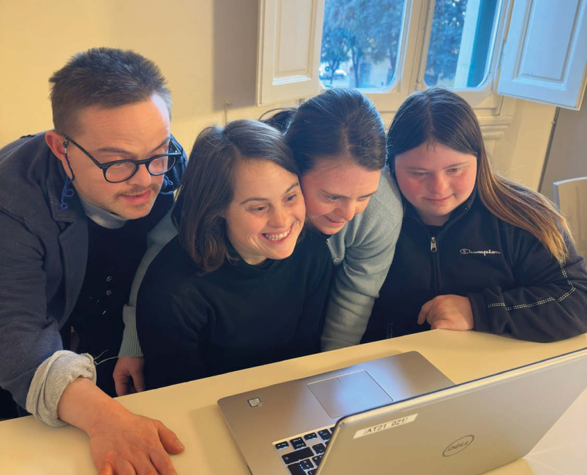 Un gruppo di giovani, un uomo e tre donne, mentre leggono un articolo al computer. La foto è stata scattata durante l'attività: Potenziamento Logopedico cognitivo adulti.