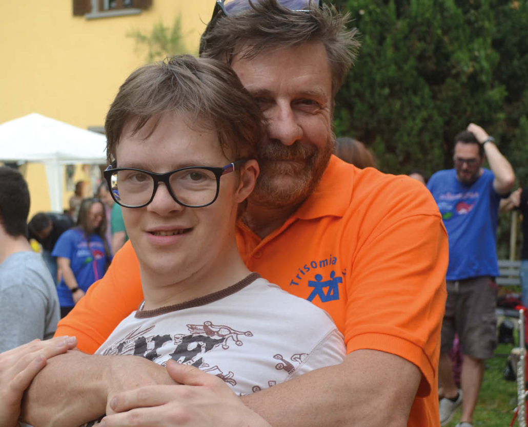 Foto di due persone, padre e figlio, sorridenti, durante una festa dell'associazione.